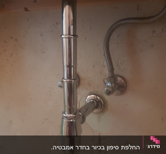 צינור מתכת מתחת לכיור עם חיבורים